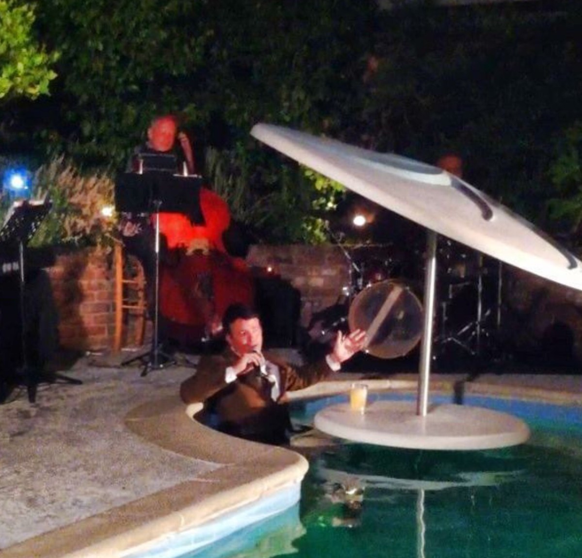Bob Caudle performing poolside with live band